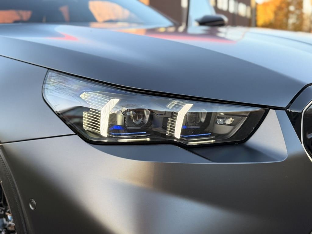 Koplamp van een matgrijze BMW M5 van dichtbij