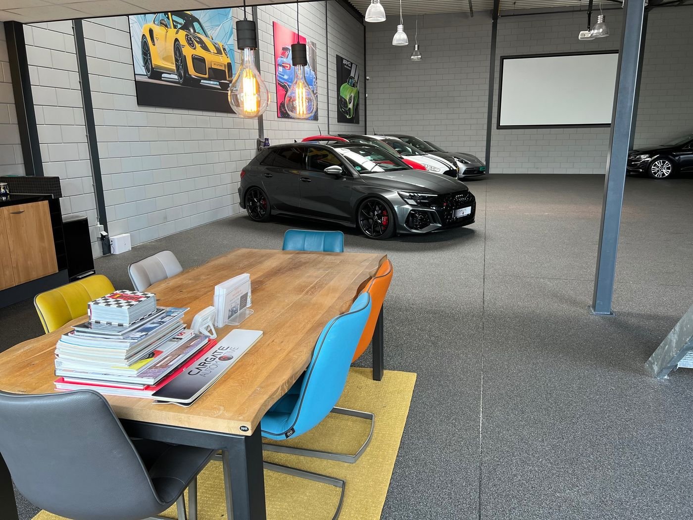 Showroom van Cargate Automotive met een zwarte sportauto en een vergadertafel